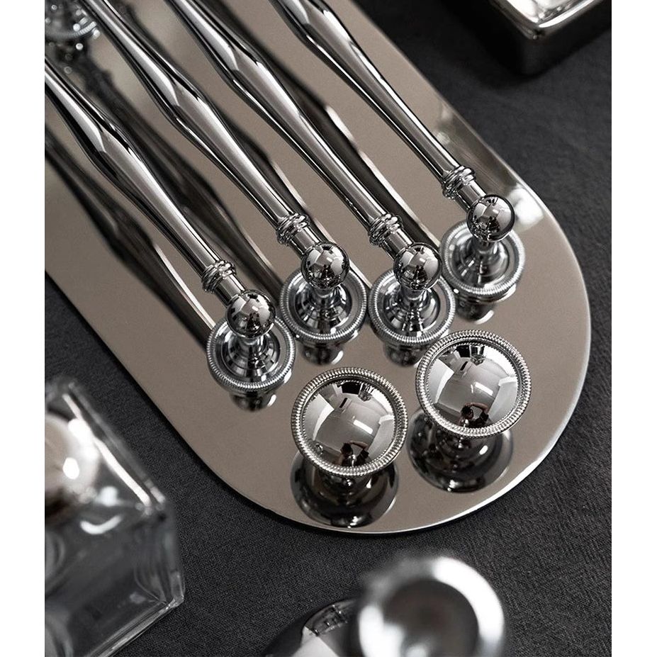 Glanzende chromen knoppen en grepen van Aurel op elegante metalen plaat, luxe meubelbeslag