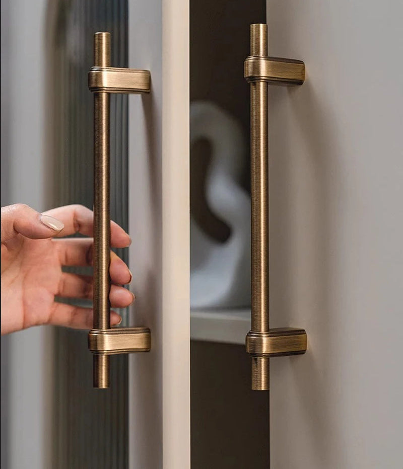 Hand pakt een luxe messing kastgreep op een moderne kastdeur, Aurel luxury hardware