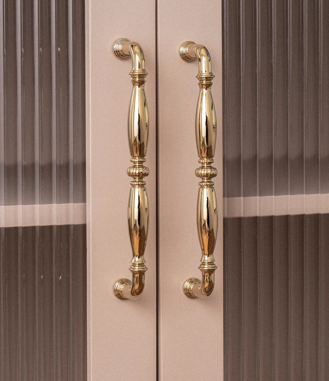 Gouden deurgrepen op beige kast met geribbeld glas, luxe Aurel hardware