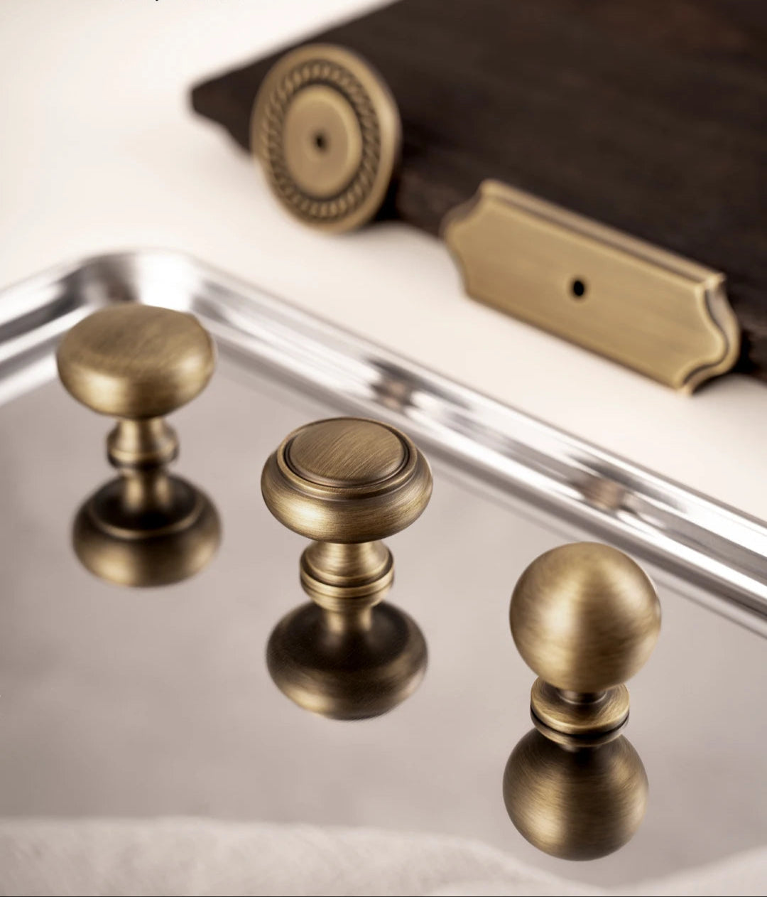 Luxe messing knoppen en grepen van Aurel op spiegelend dienblad, perfect voor interieur