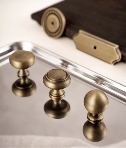 Luxe messing knoppen en grepen van Aurel op spiegelend dienblad, perfect voor interieur