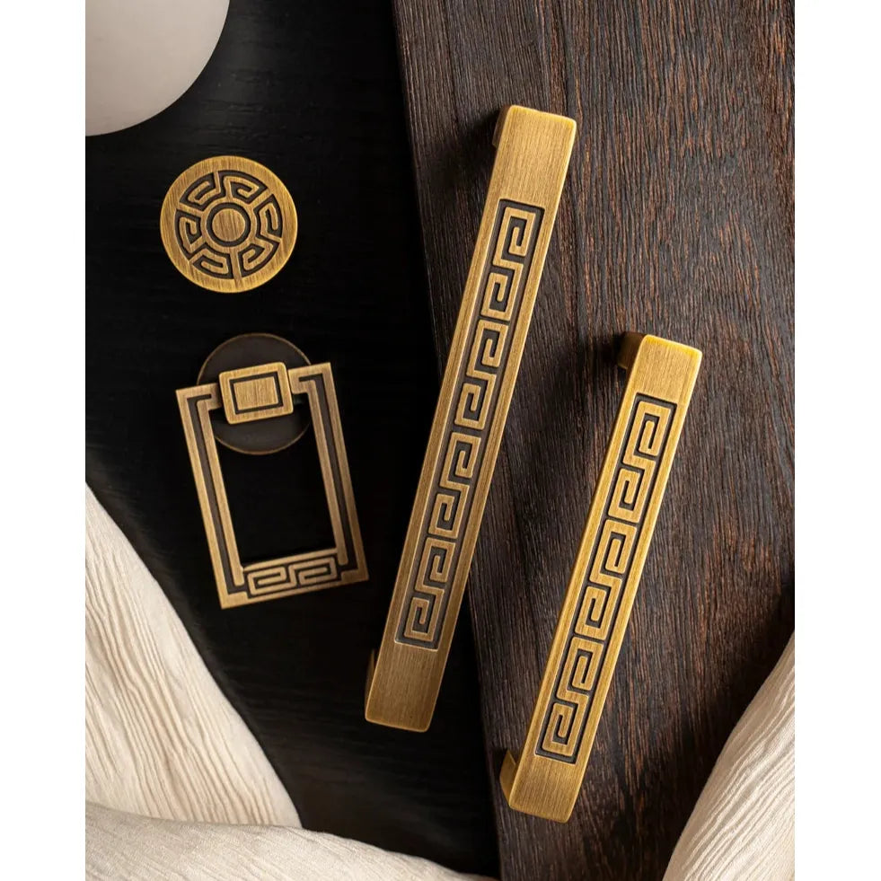 Luxe goudkleurige meubelgrepen en knoppen met geometrisch patroon op donker hout, Aurel hardware.