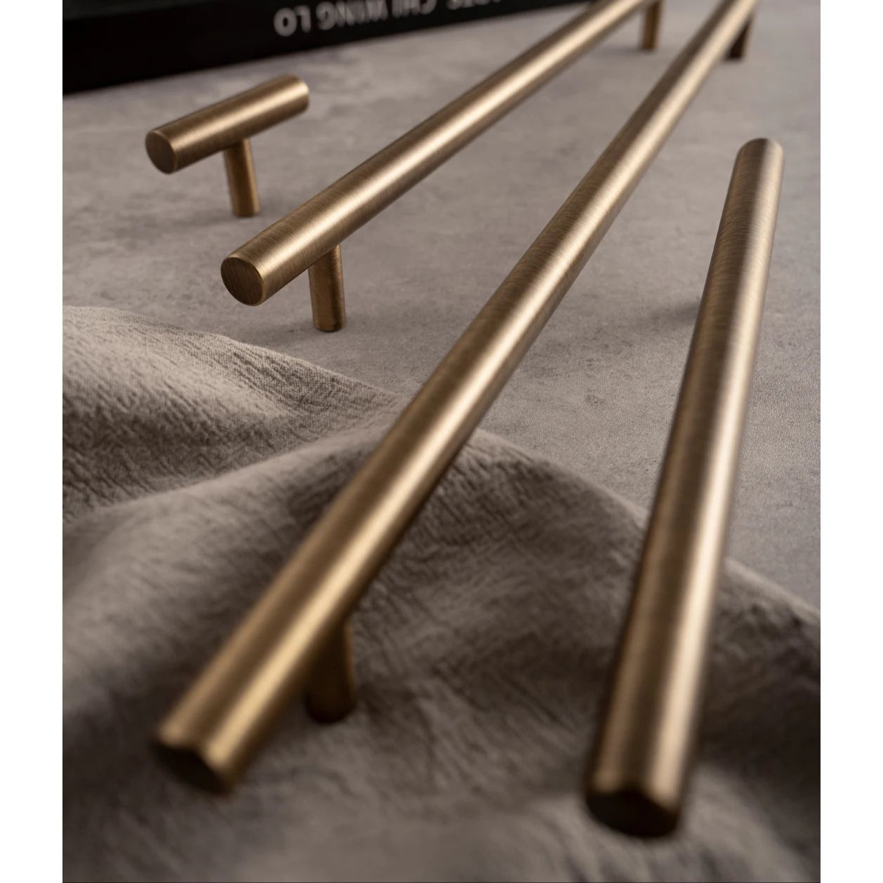 Messingkleurige Aurel grepen en knoppen op grijze ondergrond, luxe hardware voor interieurs
