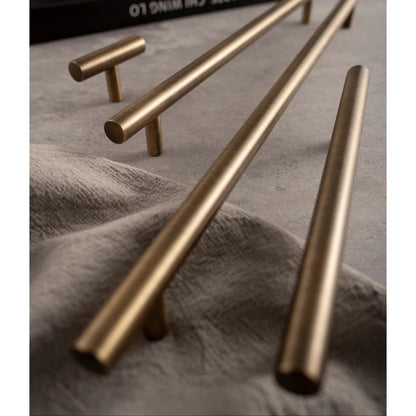 Messingkleurige Aurel grepen en knoppen op grijze ondergrond, luxe hardware voor interieurs