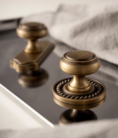 Luxe messing kastknoppen van Aurel op spiegelend oppervlak, ideaal voor modern en klassiek interieur.